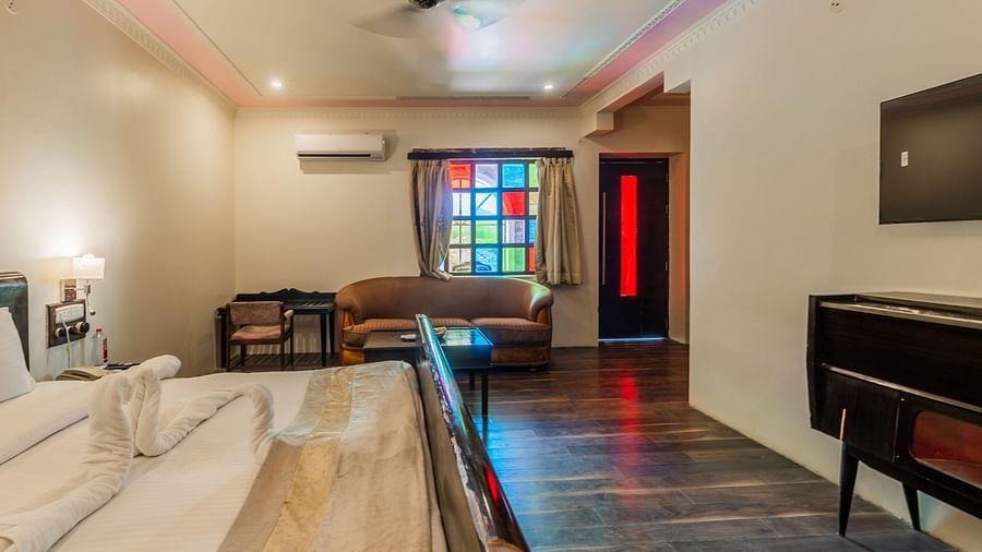 an image of a bedroom with sofa and a fan hanging from the ceiling.